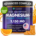 Supplement container labeled 'Secret Element' with magnesium supplement details, surrounded by oranges and gummy bears.
